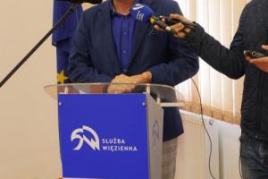 Zdjęcie przedstawia przedstawiciela firmy POMET Wronki za pupiltem konferencyjnym podczas przemawiania.
